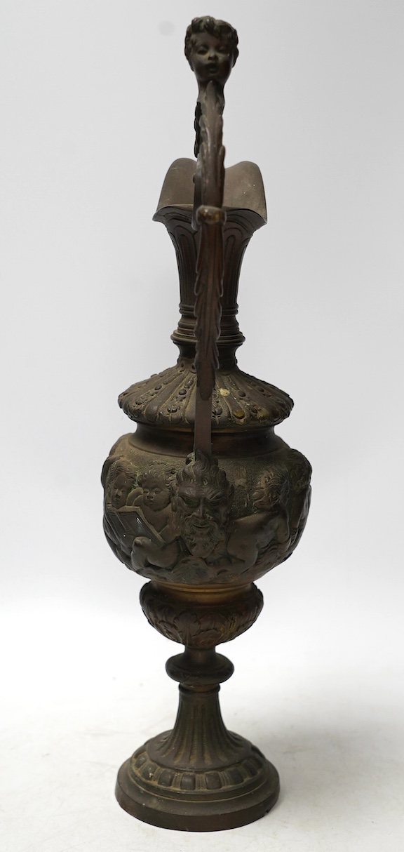 A Cellini style bronze ewer, possibly converted to a lamp later, decorated with putti panel and head handle, 42cm high. Condition - fair to good